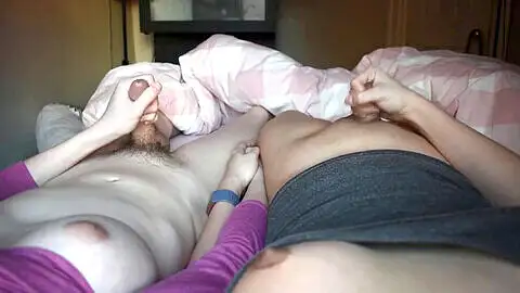 Transgender married couple share an intimate moment holding hands during orgasm